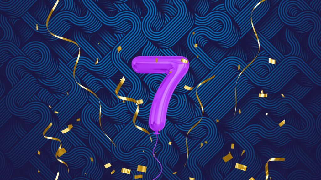 blue background, purple number 7 balloon with gold confetti
